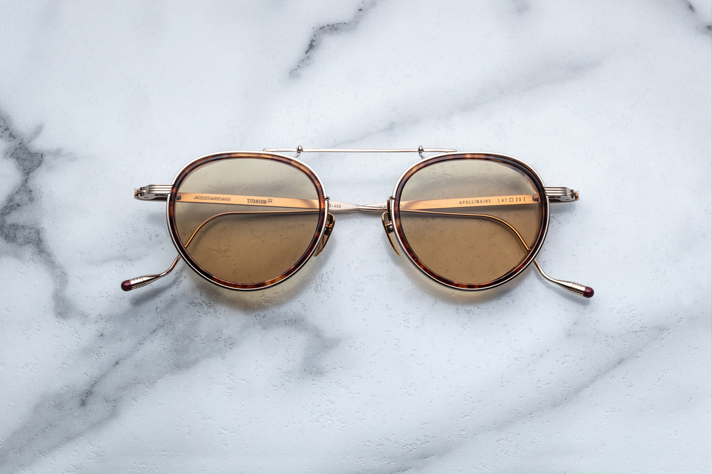 Overhead view of gold rimmed sunglasses with round brown lenses