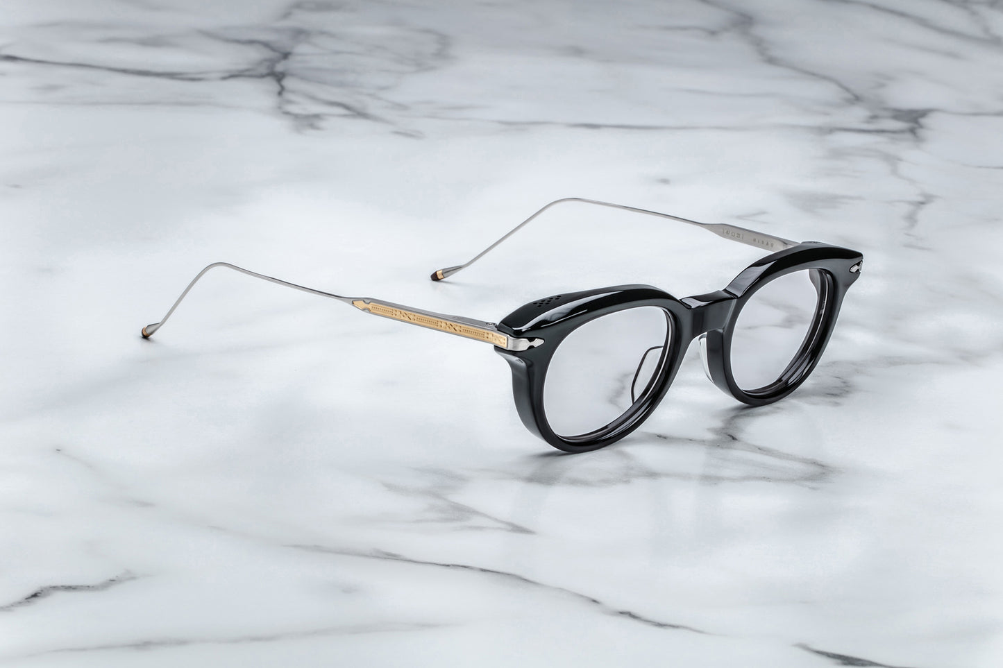 Overhead view of round black eyeglasses with gold accents