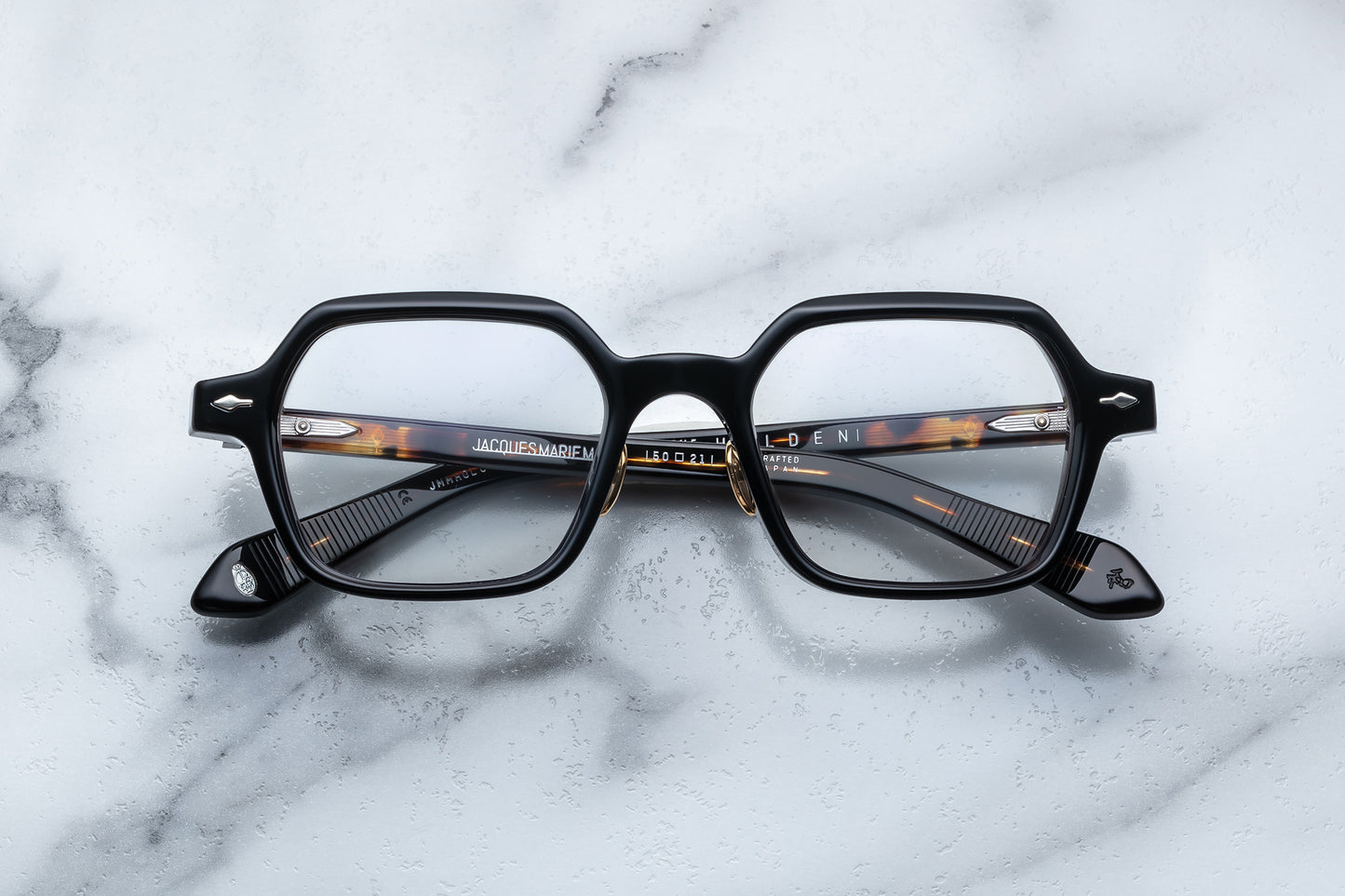 Overhead view of black hexagonal eyeglasses with silver accents
