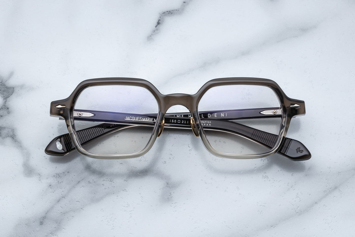 Overhead view of hexagonal eyeglasses with silver accents and a vertical brown to clear gradient