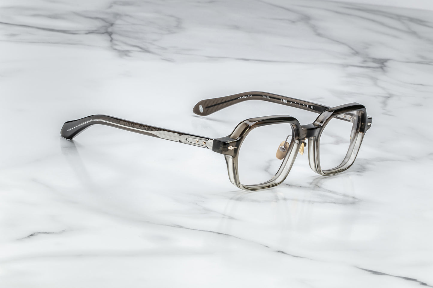Side view of hexagonal eyeglasses with silver accents and a vertical brown to clear gradient