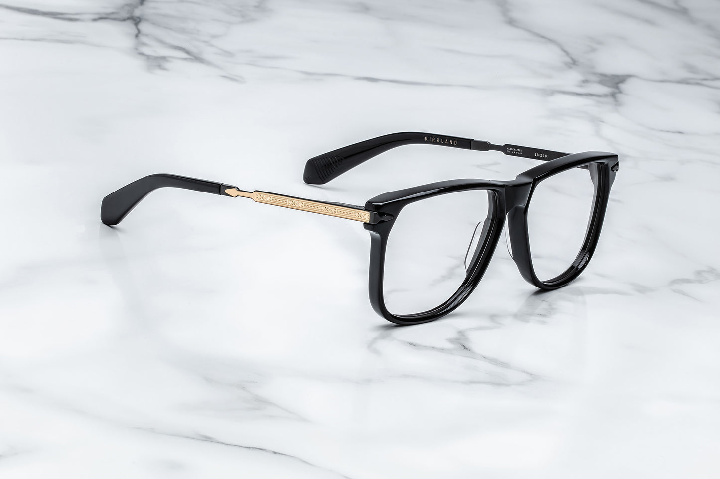 Overhead view of large black eyeglasses with gold accents
