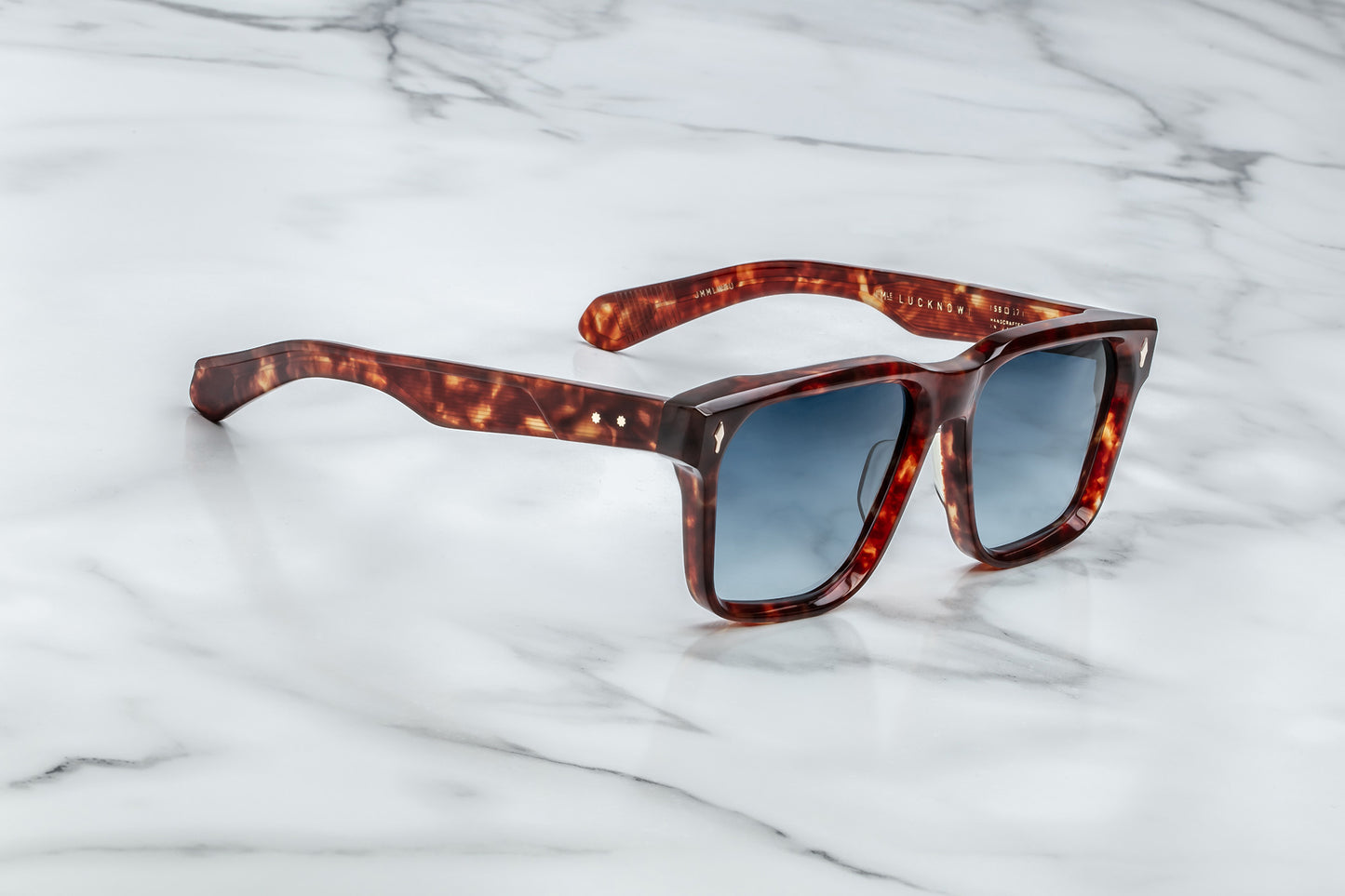 Overhead view of large rectangular sunglasses with an amber frame and blue lenses