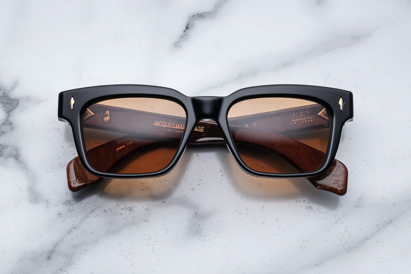 Overhead view of black rectangular sunglasses with brown orange lenses