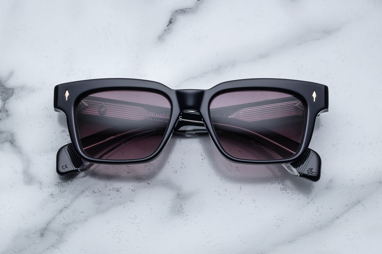 Overhead view of black rectangular sunglasses with purple lenses