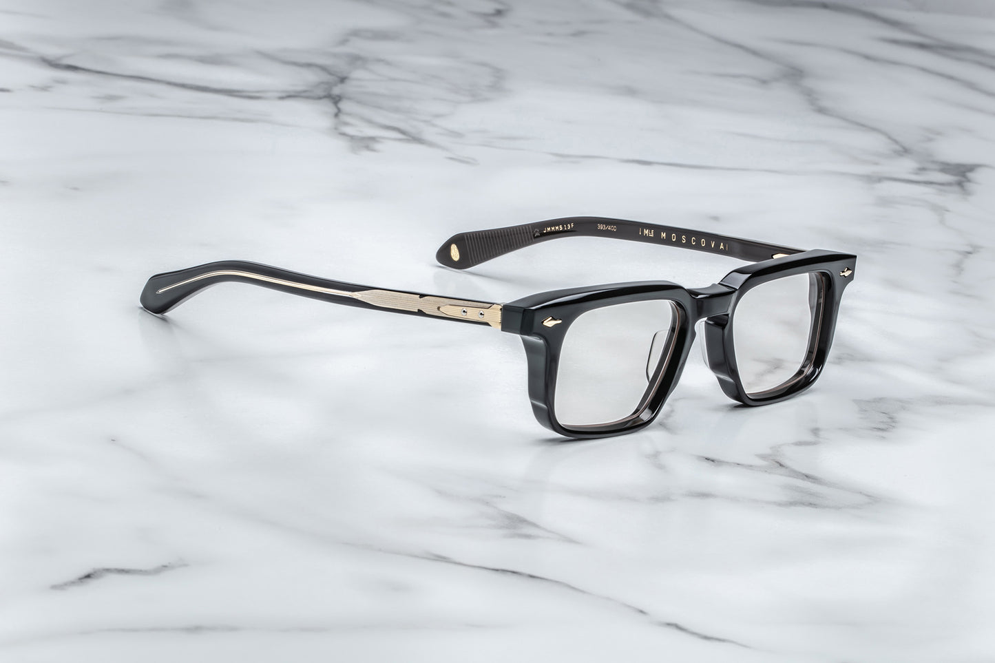 Overhead view of black rectangular eyeglasses with gold accents