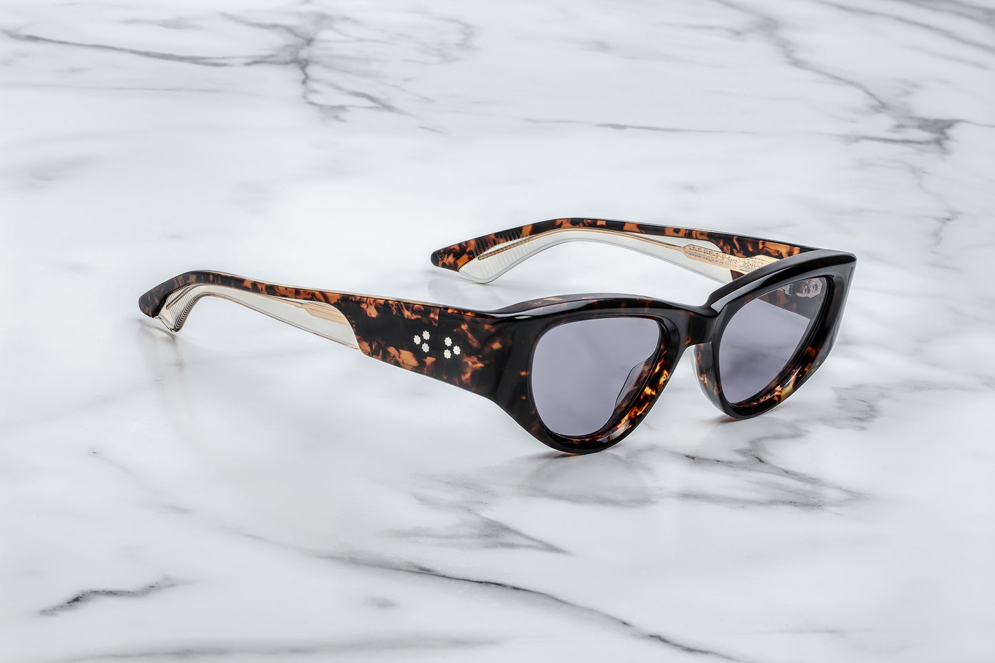 Side view of tortoise patterned cat eye sunglasses with purple lenses