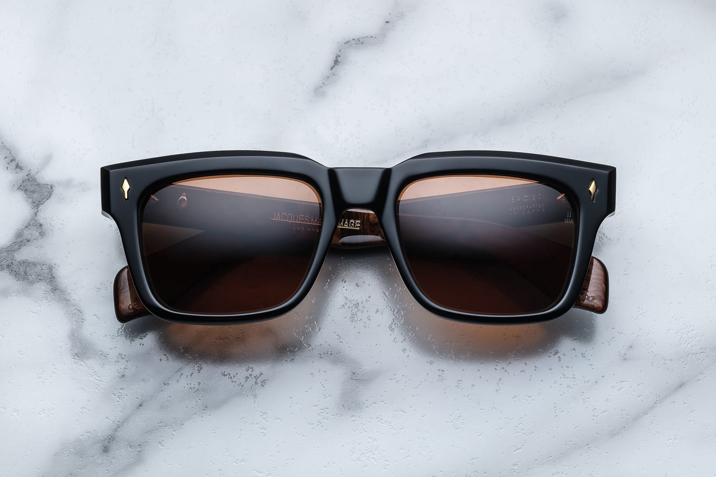 Overhead view of black rectangular sunglasses with orange lenses
