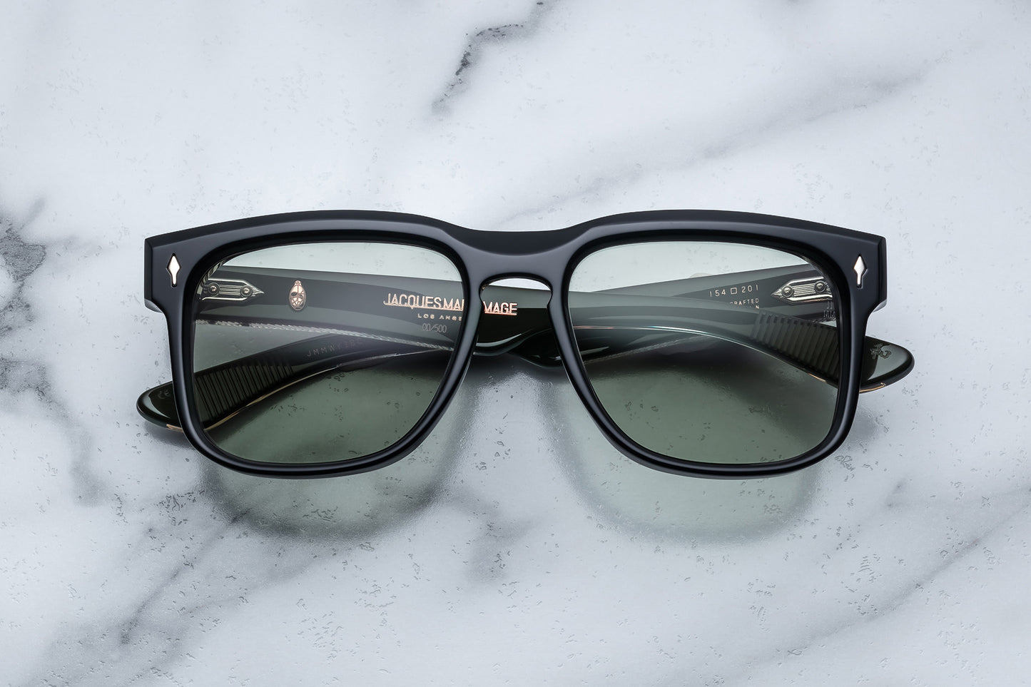 Overhead view of black rectangular sunglasses with green lenses