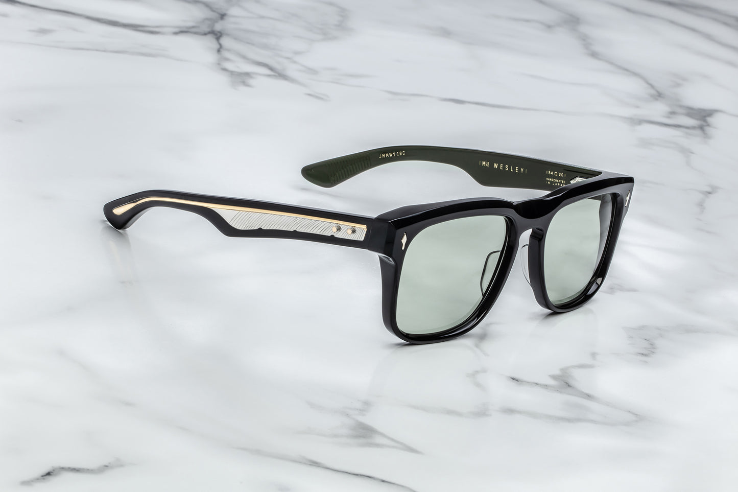 Side view of black rectangular sunglasses with green lenses