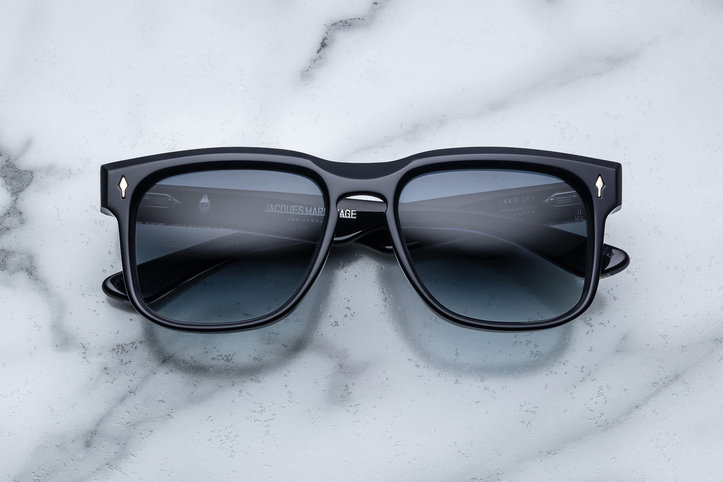 Overhead view of black rectangular sunglasses with blue lenses