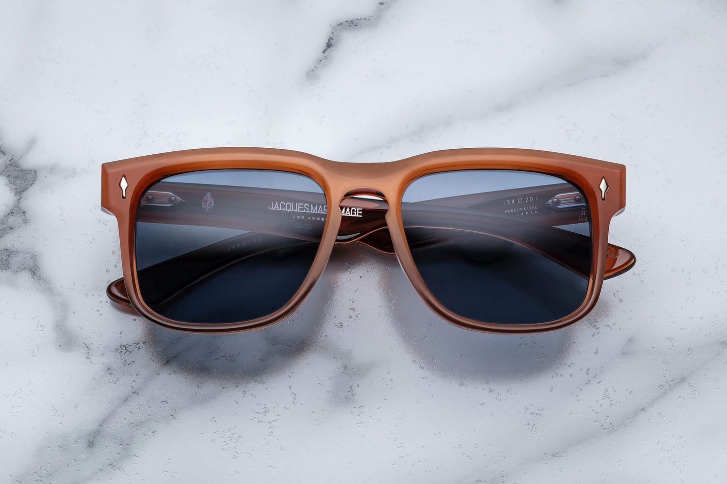 Overhead view of burnt orange rectangular sunglasses with blue lenses