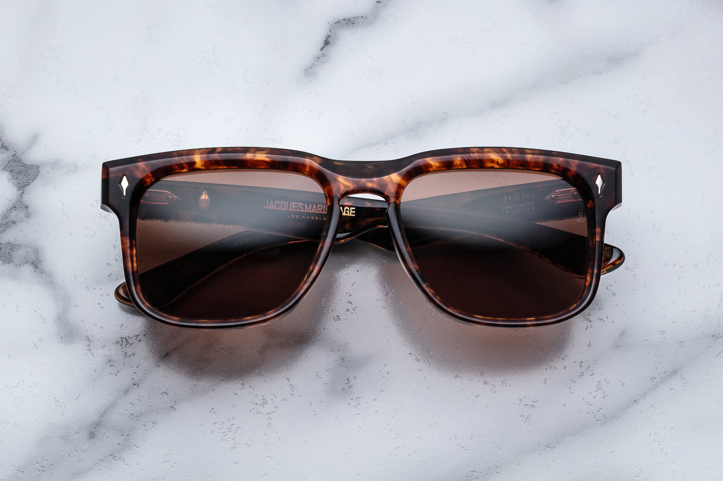 Overhead view of brown tortoise shell patterned rectangular sunglasses with brown lenses