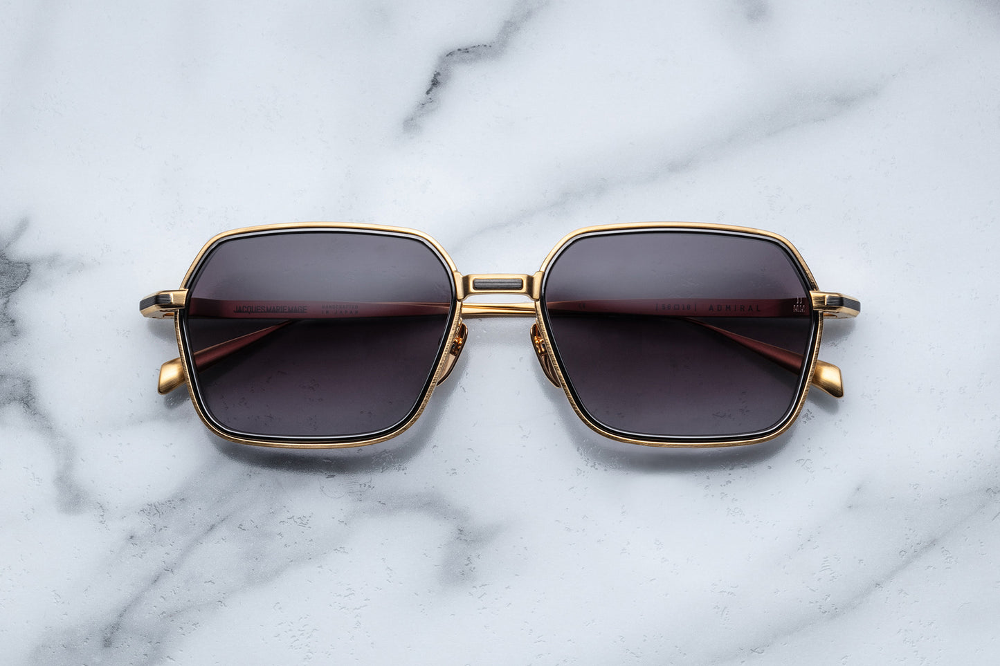 Overhead view of gold aviator sunglasses with black gradient lenses