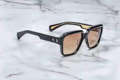 Side view of rounded rectangular black sunglasses with brown lenses