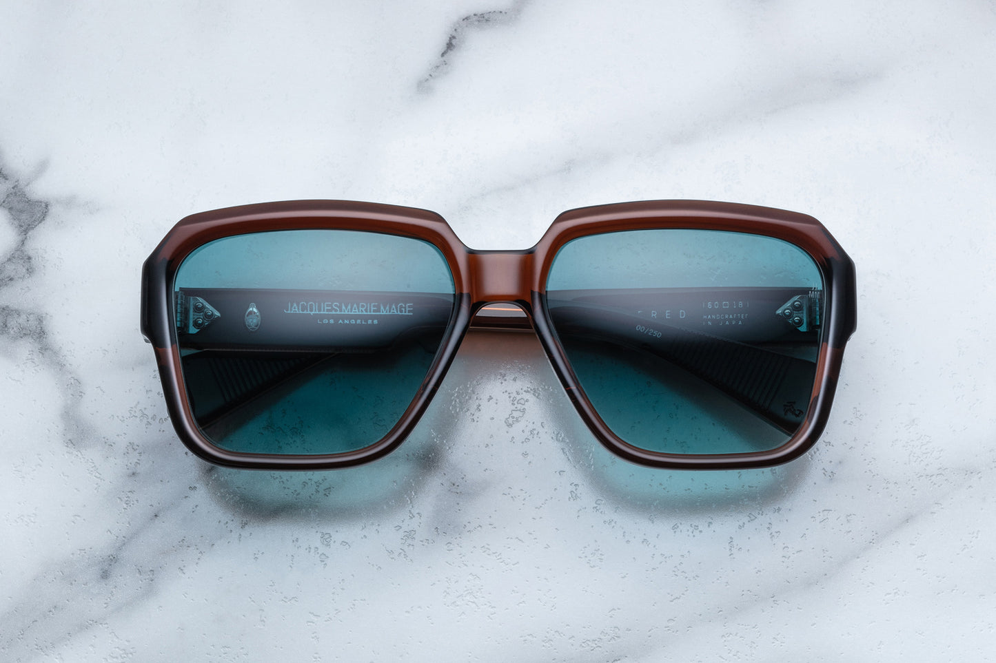 Overhead view of rounded rectangular brown sunglasses with blue lenses