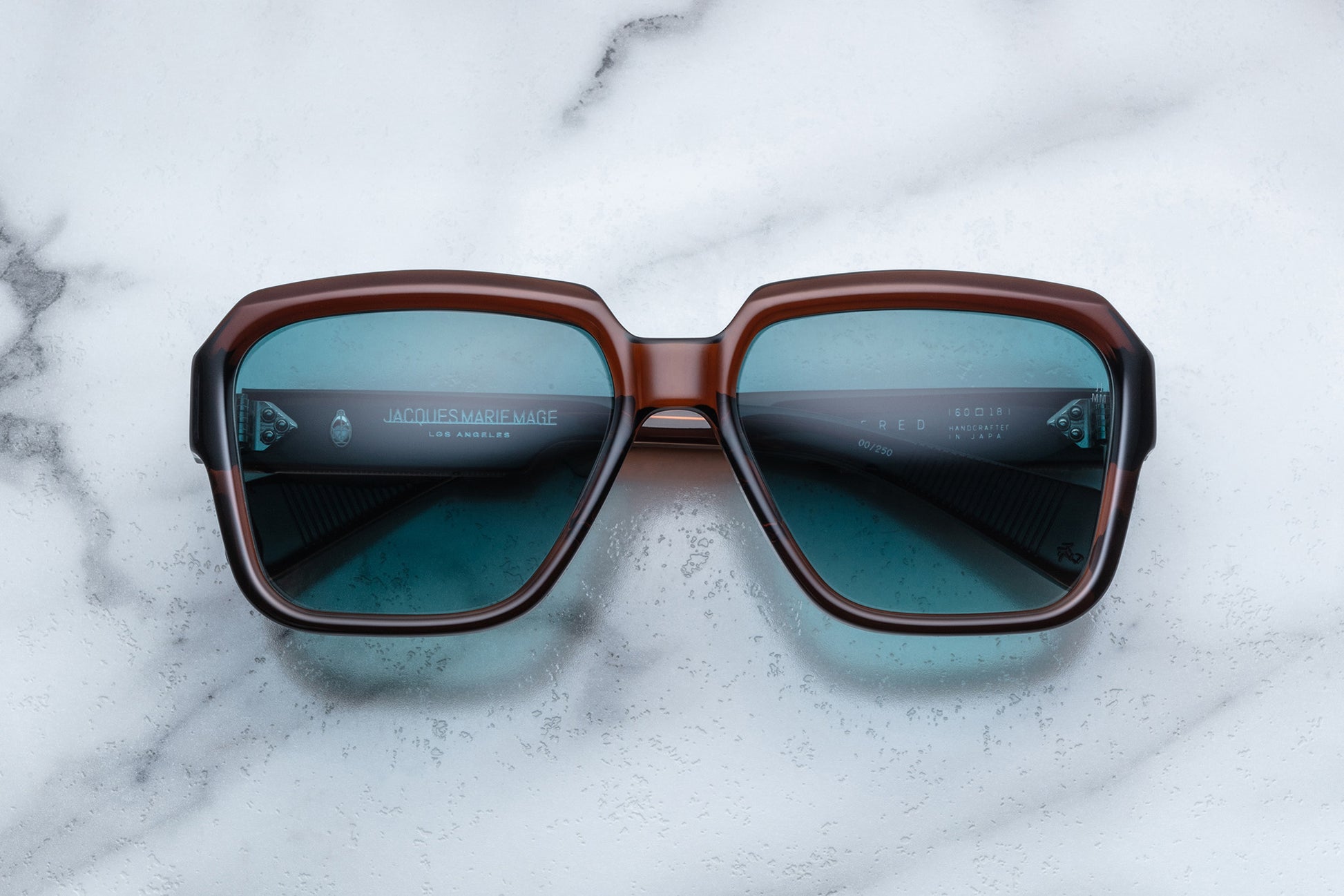 Overhead view of rounded rectangular brown sunglasses with blue lenses