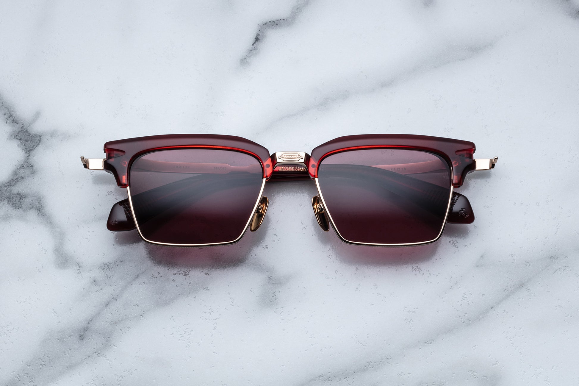 Overhead view of light gold rectangular sunglasses with red lenses