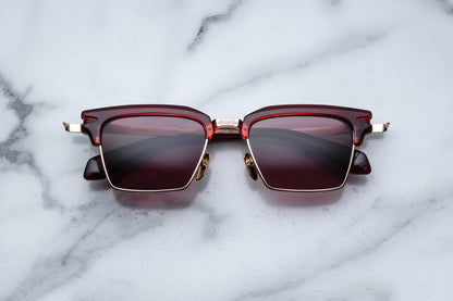 Overhead view of light gold rectangular sunglasses with red lenses