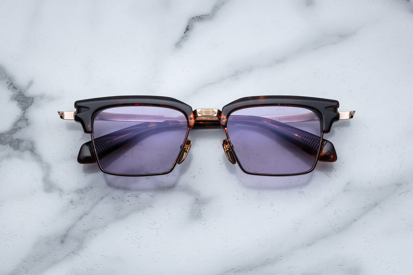 Overhead view of light gold rectangular sunglasses with lavender lenses