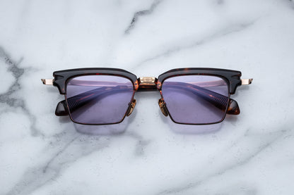Overhead view of light gold rectangular sunglasses with lavender lenses