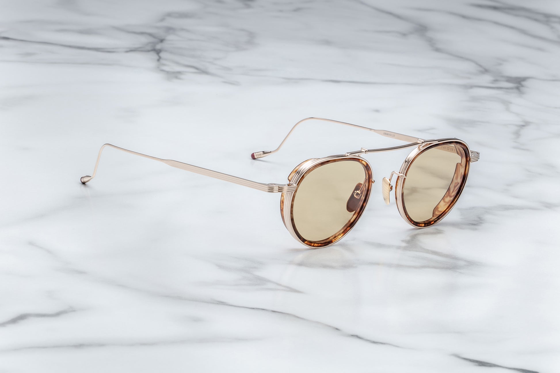 Side view of gold rimmed sunglasses with round brown lenses