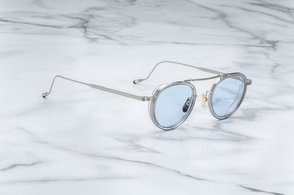 Side view of silver rimmed sunglasses with round blue lenses