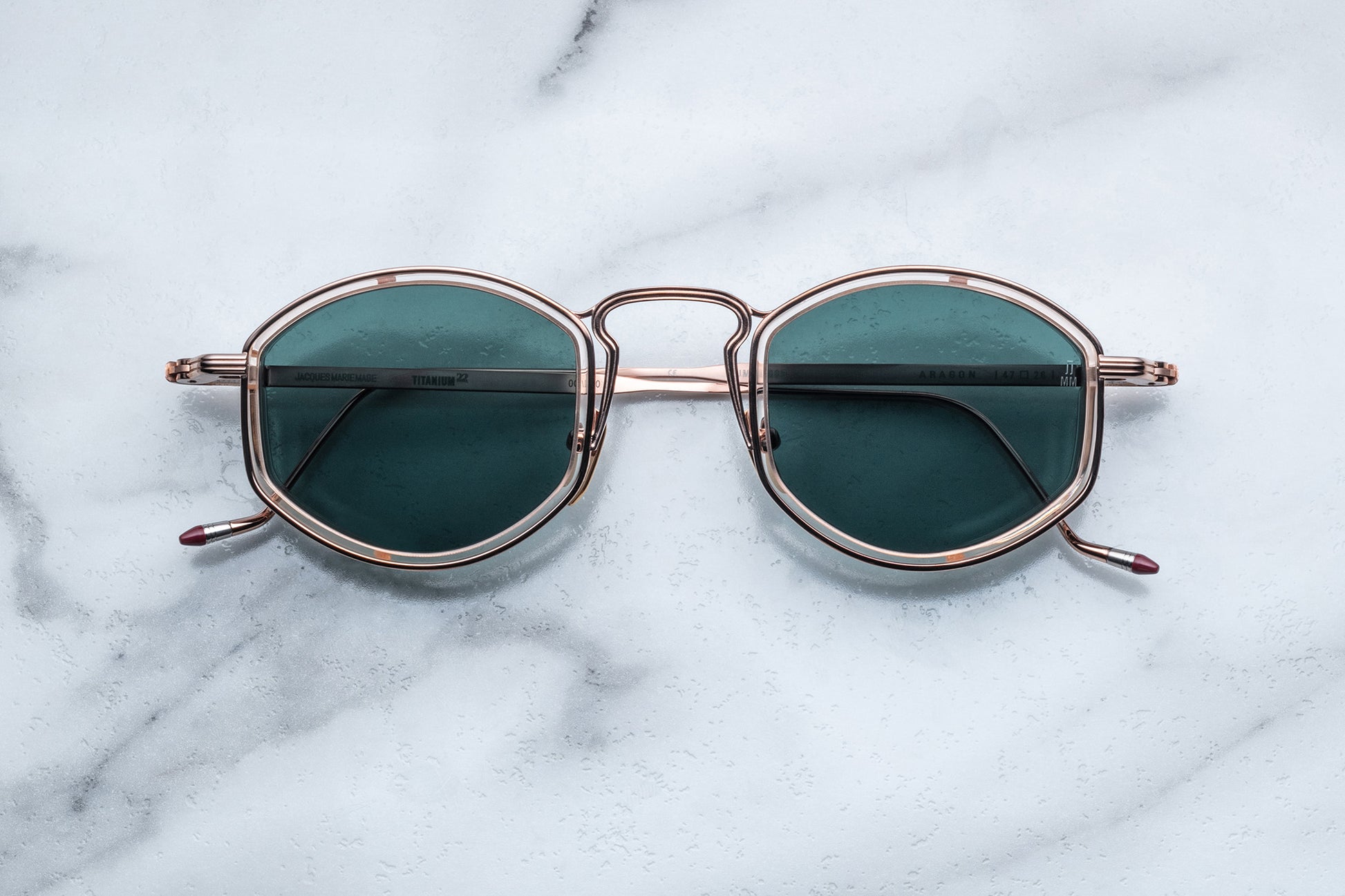 Overhead view of rose gold sunglasses with green lenses