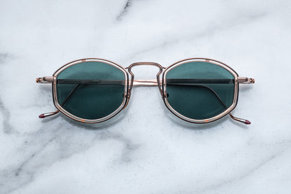 Overhead view of rose gold sunglasses with green lenses
