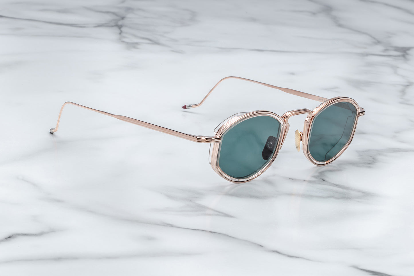 Side view of rose gold sunglasses with green lenses