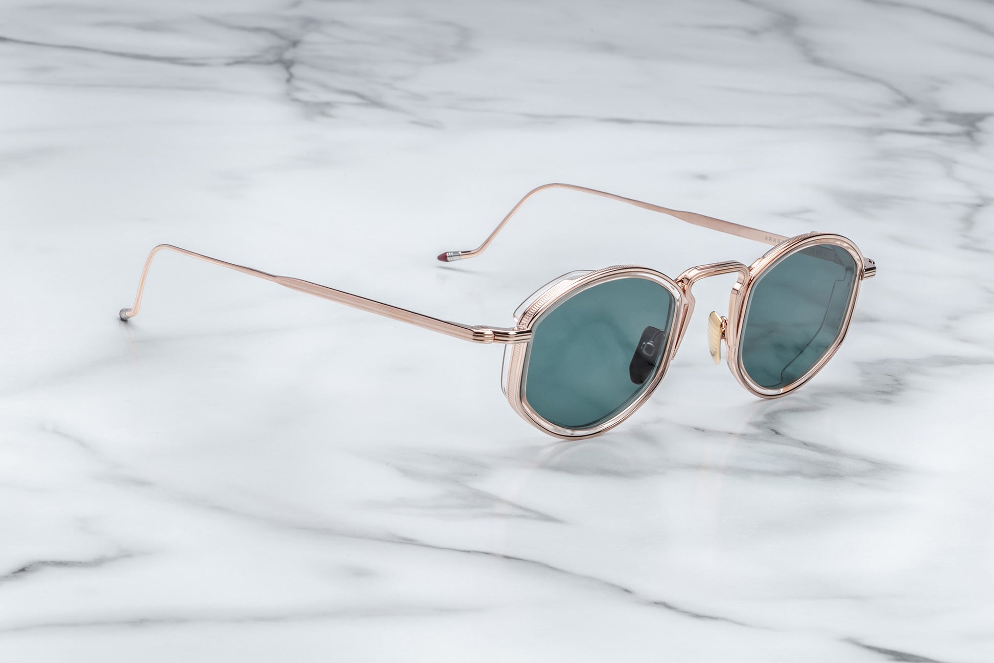 Side view of rose gold sunglasses with green lenses