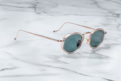 Side view of rose gold sunglasses with green lenses