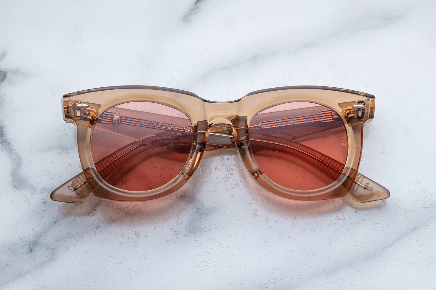 Overhead view of tan translucent sunglasses with pink lenses