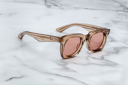 Side view of tan translucent sunglasses with pink lenses