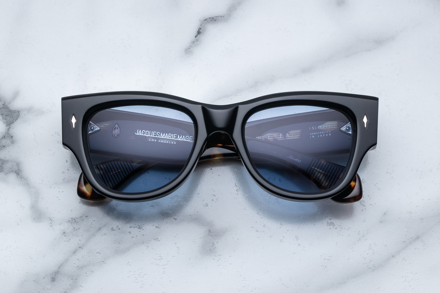 Overhead view of black sunglasses with blue lenses