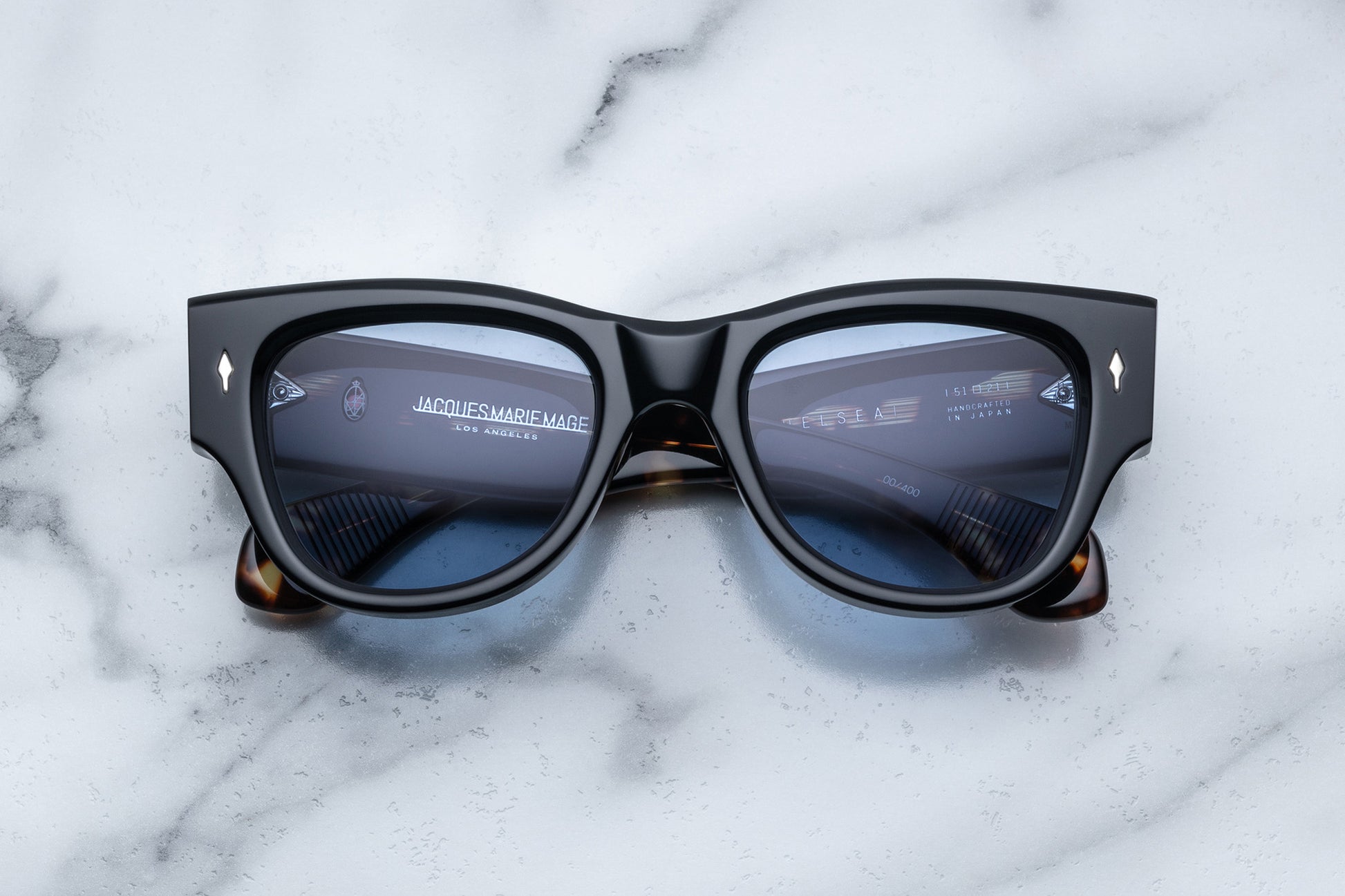 Overhead view of black sunglasses with blue lenses