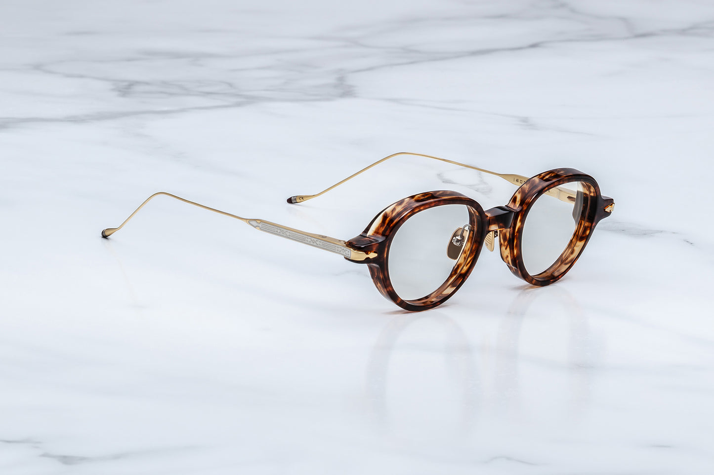 Round tortoiseshell glasses on a marble surface