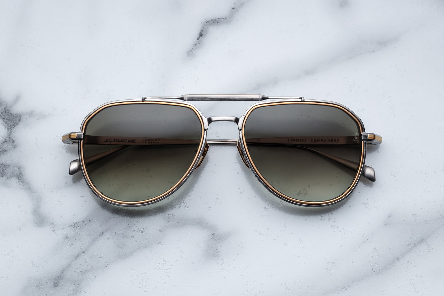 Overhead view of silver and gold aviator sunglasses with light green lenses