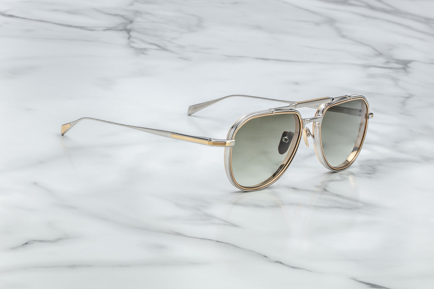 Side view of silver and gold aviator sunglasses with light green lenses