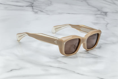 Profile view of beige cat eye sunglasses with brown lenses