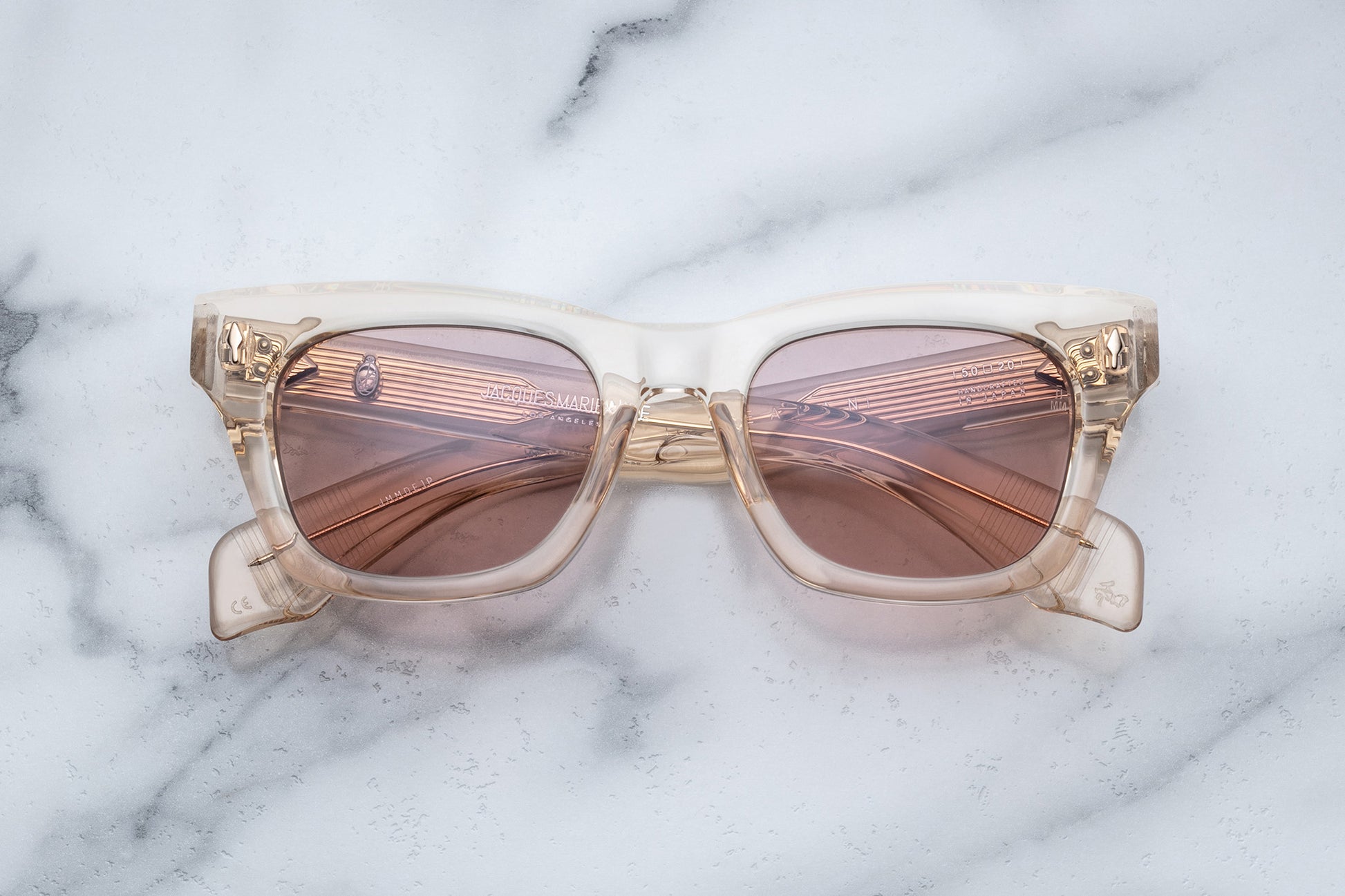 Overhead view of dusty rose translucent rectangular sunglasses with mauve lenses