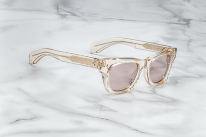Overhead view of dusty rose translucent rectangular sunglasses with mauve lenses
