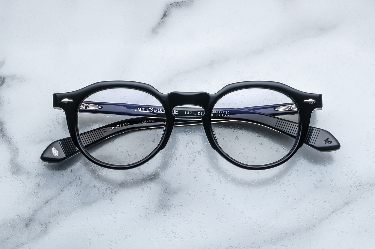Overhead view of black round eyeglasses with silver accents