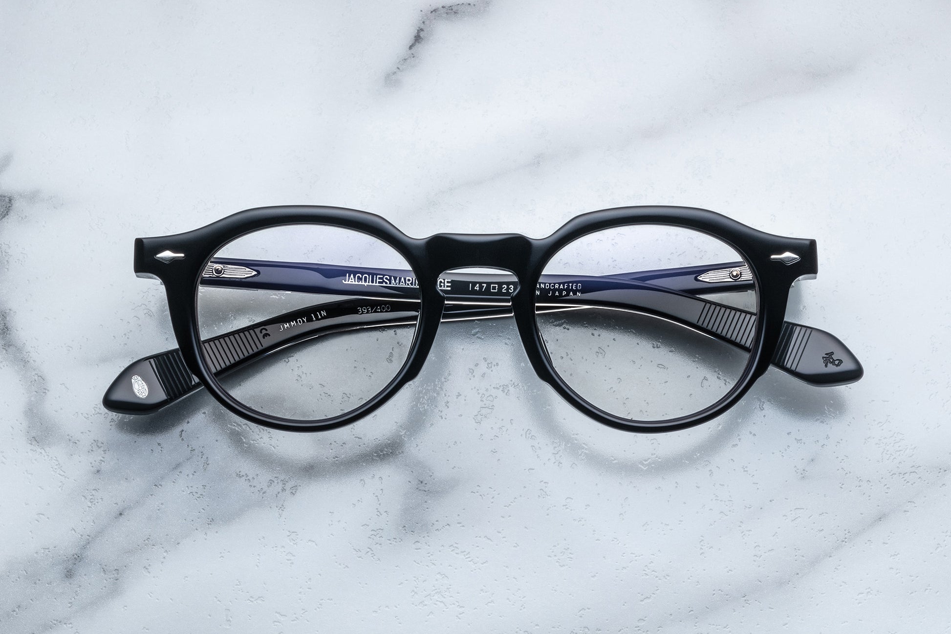 Overhead view of black round eyeglasses with silver accents