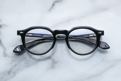 Overhead view of black round eyeglasses with silver accents