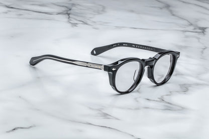 Side view of black round eyeglasses with silver accents