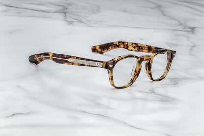 Side view of tortoise patterned round eyeglasses with silver accents