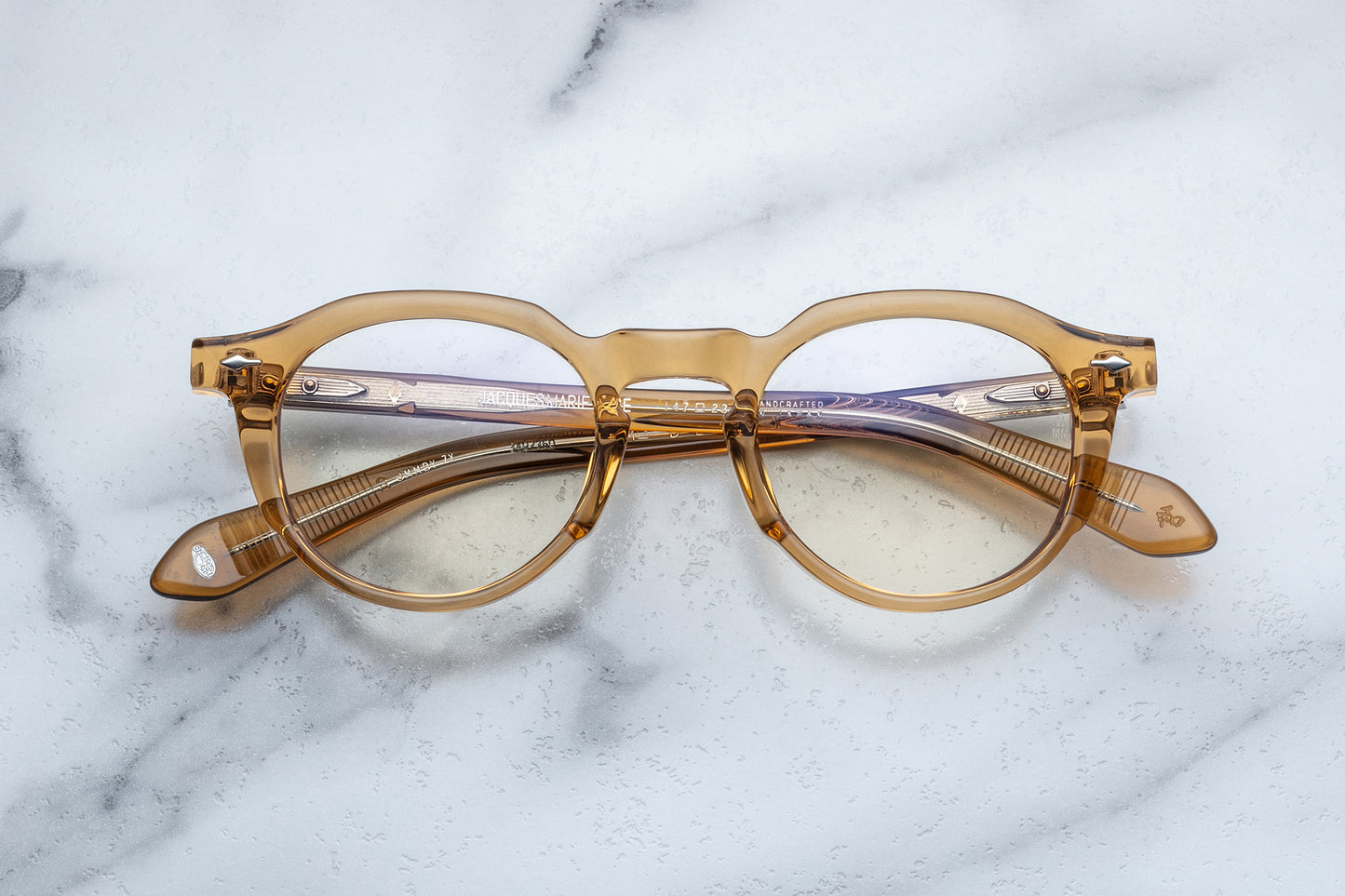 Overhead view of light brown translucent round eyeglasses with silver accents
