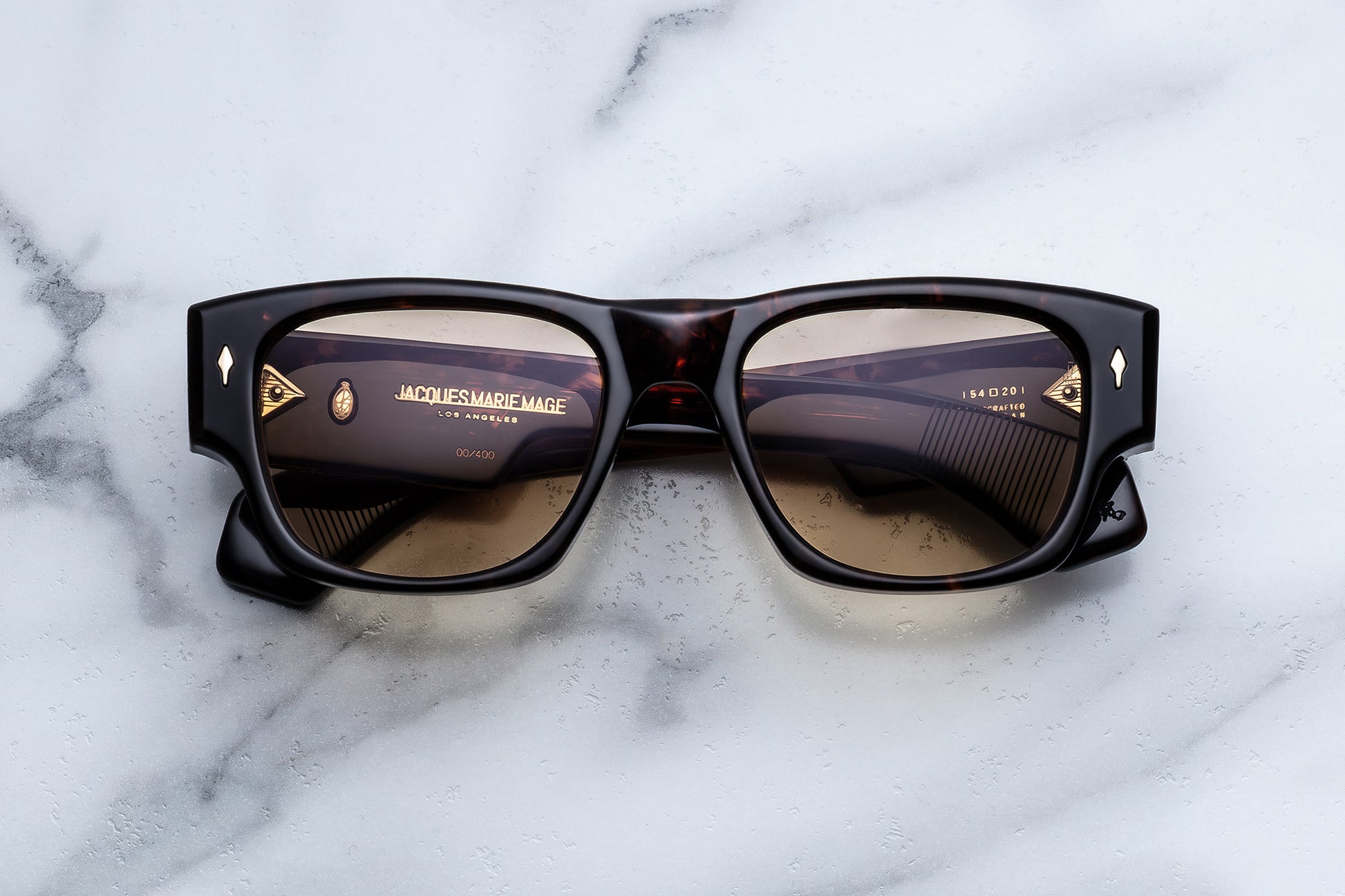 Sunglasses with gold accents on a marble surface
