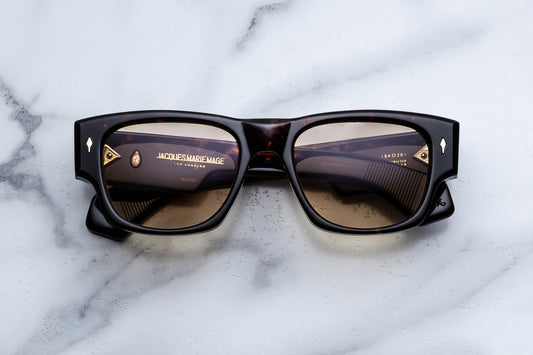 Sunglasses with gold accents on a marble surface